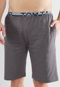 Gray cotton shorts with an elastic waistband featuring blue "TOM TAILOR" logo. Includes side pockets and a relaxed fit design.