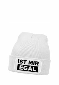 White knit beanie featuring a folded cuff with a rectangular patch displaying the text "IST MIR EGAL" in bold black letters.