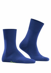 Niebieskie skarpetki sięgające kostek z prążkowanym ściągaczem, gładką fakturą i kontrastującym zielonym logo marki z boku. Minimalistyczny design, bez wzorów.