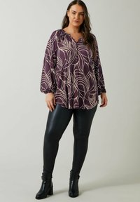 Lilla bluse med cremefarvet bladmønster, afslappet pasform, rynket halsudskæring, lange ærmer. Sættes sammen med sorte læderleggings og ankelstøvler.