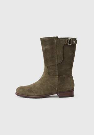 Stivaletti alla caviglia in suede verde oliva con punta rotonda, design cucito e un accessorio in metallo a forma di fibbia sul lato. Tacco spesso marrone.