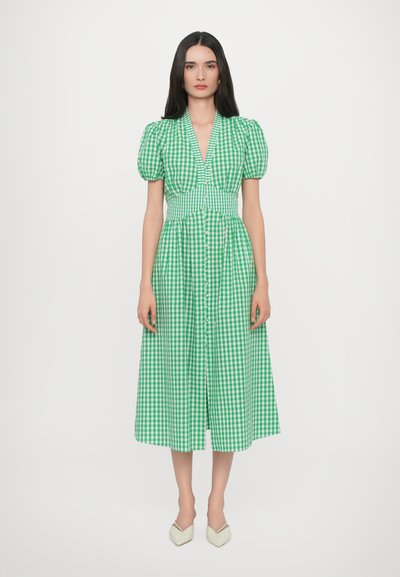 Vestito midi a quadretti verdi con maniche a sbuffo, scollo a V profondo, vita aderente e chiusura frontale con bottoni. Tessuto liscio con motivo a quadretti.