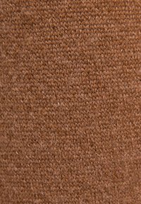 Brązowa dzianina o gładkiej fakturze, charakteryzująca się regularnym wzorem łączących się ściegów oraz subtelnymi odcieniami.