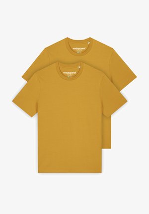 Deux t-shirts en coton jaune moutarde, à manches courtes, col rond, avec une étiquette imprimée à l'intérieur portant un logo de marque. Texture lisse.