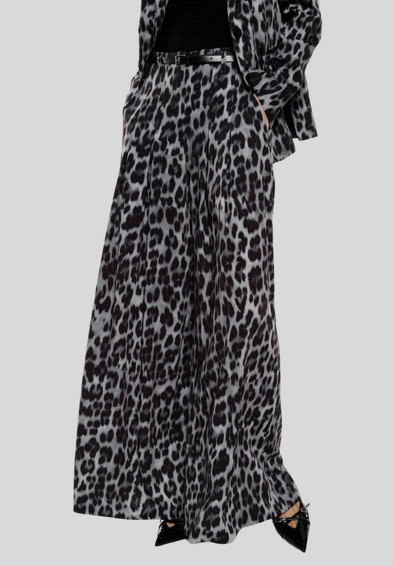 Pantaloni a gamba larga con stampa leopardata in tessuto nero e grigio. Caratterizzati da tasche laterali, vita aderente e una texture liscia.