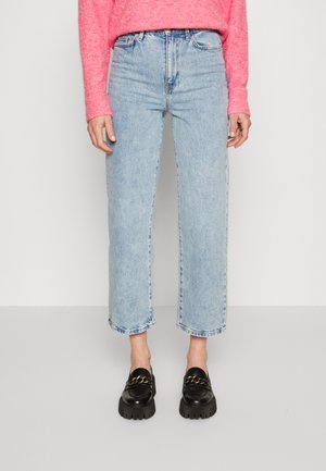 Light blue high-waisted jeans with a straight leg design, featuring raw hems and a classic five-pocket style. Paired with black loafers.