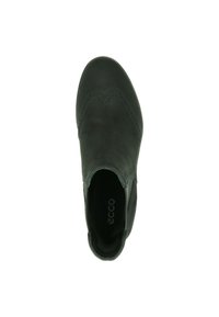 Chaussure en cuir noir avec un bout arrondi, des détails décoratifs en brogue et des inserts élastiques sur les côtés. Texture lisse et design minimaliste.