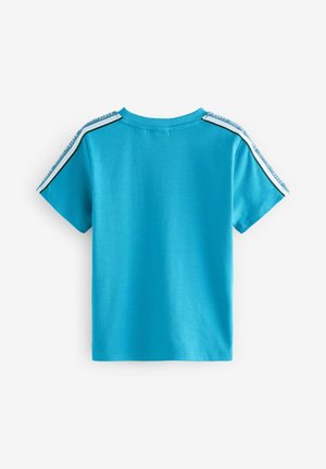 T-shirt a maniche corte di colore turchese realizzato in cotone, con collo rotondo e strisce laterali a contrasto con accenti testuali. Texture liscia.