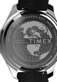 Der Uhrenboden aus Edelstahl verfügt über ein Globusdesign, eingravierten Text und ein schwarzes, strukturiertes Stoffarmband für sicheren Halt.