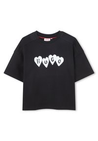 Μαύρο κοντομάνικο T-shirt με τη λέξη "HUGO" γραμμένη με λευκά γράμματα μέσα σε πέντε καρδιές κατά μήκος του στήθους.