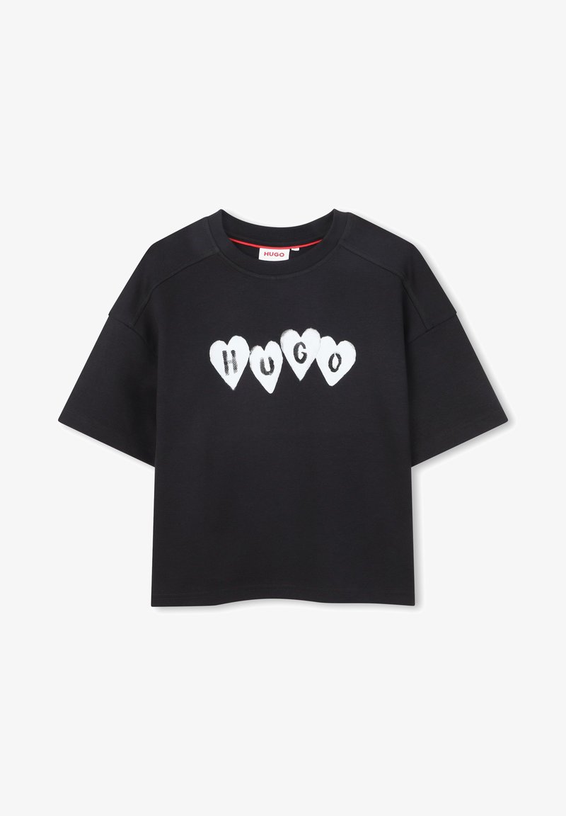 Μαύρο κοντομάνικο T-shirt με τη λέξη "HUGO" γραμμένη με λευκά γράμματα μέσα σε πέντε καρδιές κατά μήκος του στήθους.