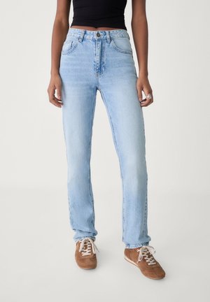 Jean bleu clair taille haute en denim, avec une conception traditionnelle à cinq poches, coupe droite et texture subtilement délavée.