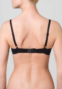 Sort stof bh med justerbare tynde stropper, hægte-lås, slankt design og glat tekstur, der viser en minimalisk stil.