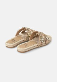 Beige slip-on sandals with dual wide straps adorned with sequins and beads, featuring a braided jute sole and textured footbed.