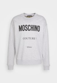 Šedá mikina z bavlny s výrazným černým textem: "MOSCHINO COUTURE! Milano" přes hrudník, s žebrovanými manžetami a lemem.