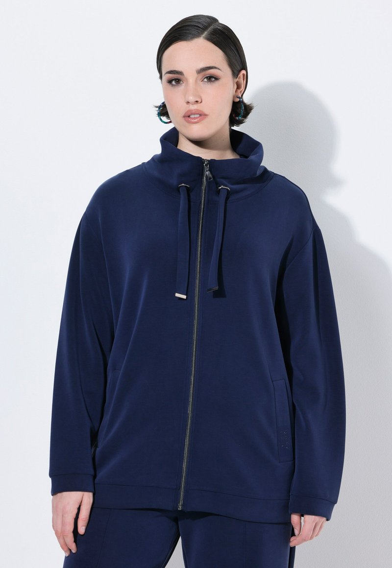 Felpa zip blu navy realizzata in tessuto morbido, con colletto alto, cordini e tasche laterali, dal fitting morbido e con maniche lunghe.