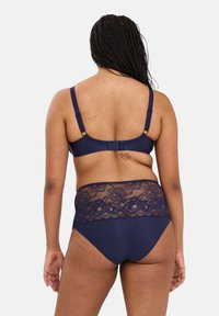 Marine blauwe kanten beha en set van hoge tailleslip met een kanten detail op de tailleband, verstelbare bandjes en een gladde afwerking.