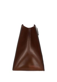 Sac à main en cuir marron foncé avec une forme trapézoïdale et une texture lisse, montré de côté sur un fond blanc.