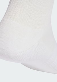 Calzino bianco in cotone con una texture a coste, dotato di punta senza cuciture e tallone rinforzato per una maggiore durata. Design pulito e semplice.