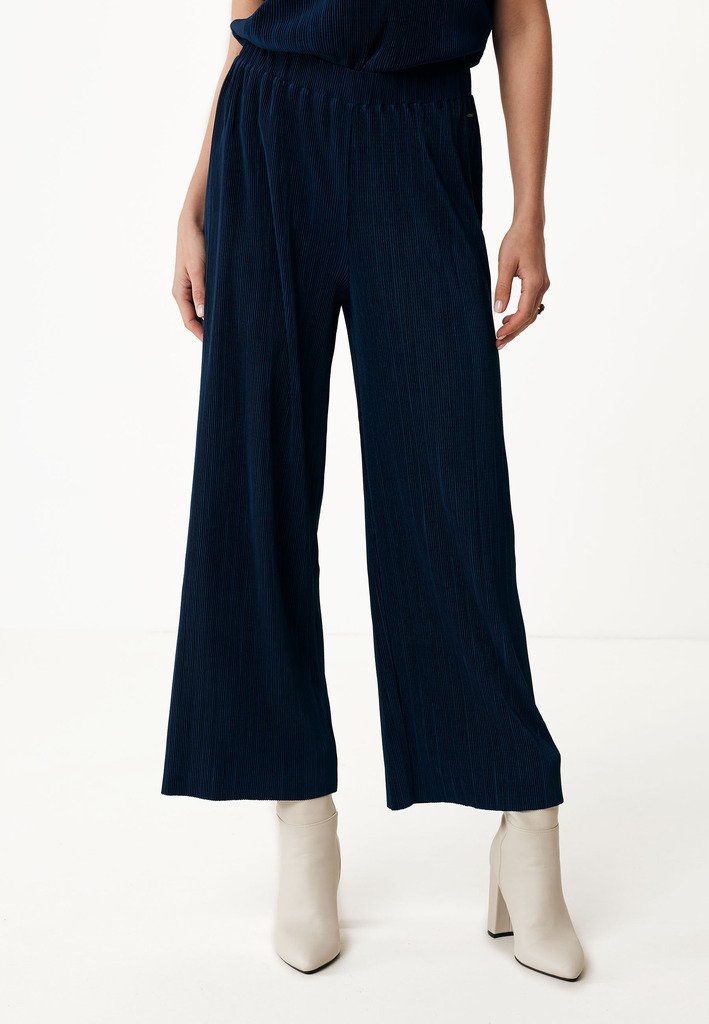 Marinblå vida byxor med ribbat mönster och elastiskt midjeband, matchat med beige ankelboots.
