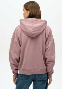Hooded sweatshirt in dusty pink, made of soft fabric, featuring a relaxed fit and ribbed cuffs; back view shows hood seam detail and no graphics.