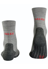 Calcetines tobilleros grises con parte superior acanalada, que presentan un talón y una puntera más oscuros. Logo "FALKE" en rojo en el lateral, con acentos texturados en la suela.