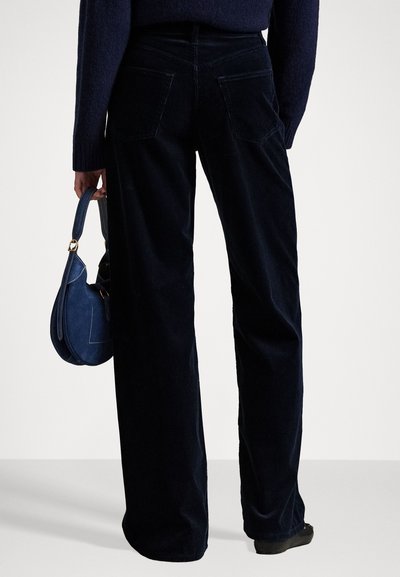 Navy corduroy wide-leg pants with two back pockets, paired with a small blue handbag. Smooth texture, subtle vertical lines.