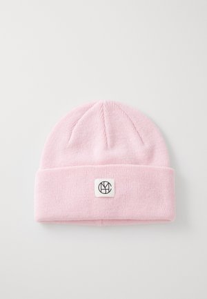 Lichtroze gebreide beanie met een omgevouwen boord. Heeft een klein vierkant label met een zwart logo aan de voorkant. Zachte textuur en naadloos ontwerp.