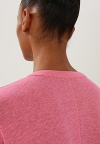 Kortärmad t-shirt med rund halsringning i en livlig rosa bomullsblandning. Har en texturerad yta med en subtil sömdetalj på baksidan.