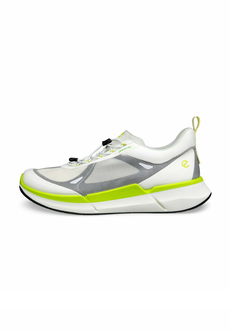 Scarpa sportiva bianca con pannelli in rete e accenti verde neon. Presenta una suola testurizzata, lacci regolabili e un manico sul tallone.
