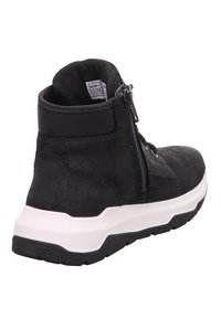 Bottine en daim noir avec une semelle épaisse blanche, fermeture éclair sur le côté et un dessus texturé. Présente un col rembourré pour plus de confort.