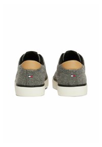 Gray fabric sneakers with a smooth texture, rounded heel, white rubber sole, and subtle brand logo near the heel. Black accents at the opening.