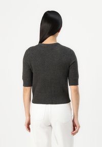 Pull en maille gris foncé à manches courtes avec un col et un ourlet côtelés, texture douce et coupe courte. Vue de dos montrée.