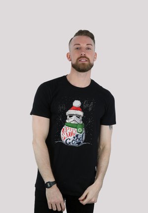 Black T-shirt featuring a graphic design of a stormtrooper wearing a Santa hat, with "Up to Snow Good" text in colorful lettering.
