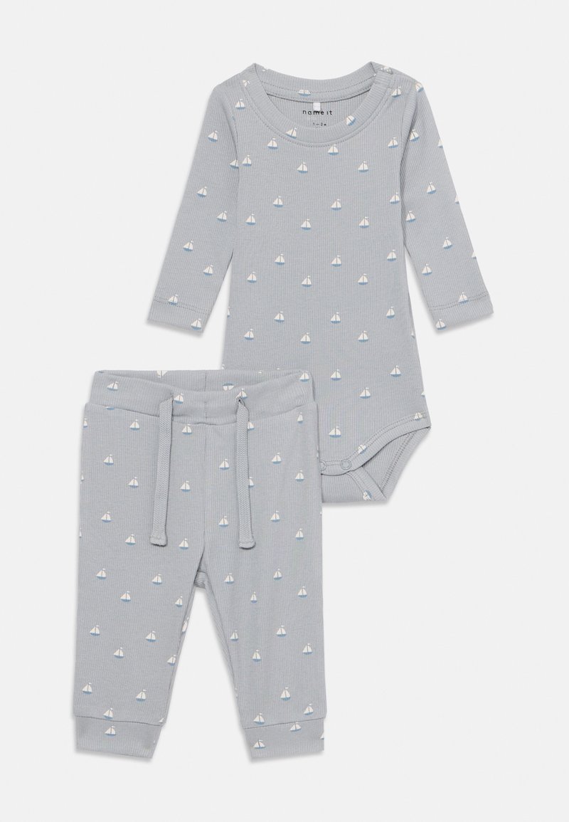 Completo per neonato grigio chiaro con maniche lunghe e pantaloni, caratterizzato da un motivo a vela. Realizzato in morbido tessuto a coste con una vestibilità aderente.
