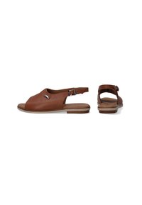 Bruine leren sandalen met een open teen ontwerp, een verstelbare enkelband en een platte zool. Voorzien van een kleine metallic accent aan de zijkant.