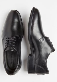Scarpe eleganti nere in pelle con una finitura liscia. Caratterizzate da una punta arrotondata, un classico design con lacci e un tacco a blocco. Dettaglio di cucitura sottile.