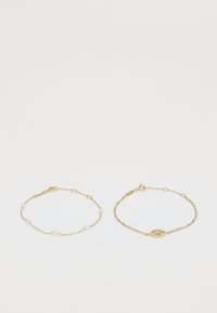 Gold multi-strand bracelet set featuring delicate chain links, small white pearls, and an eye-shaped accent with clear gemstones.