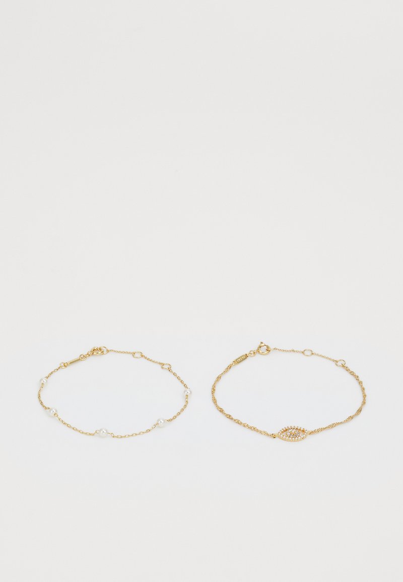 Gold multi-strand bracelet set featuring delicate chain links, small white pearls, and an eye-shaped accent with clear gemstones.