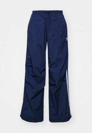 Pantaloni da track a gamba larga di colore blu navy, realizzati in tessuto leggero. Dispongono di una vita elastica con cordoncino e strisce bianche laterali.