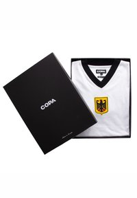 Folded white soccer jersey with black V-neck and German eagle crest inside a black box labeled COPA.