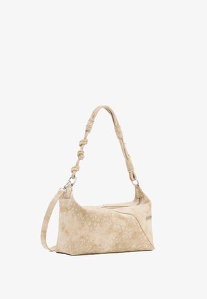 Bež torba s urezanim cvjetnim uzorcima, s detaljima u čvoru na naramenici i srebrnim ukrasima na patent zatvaraču.