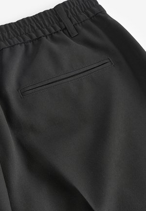 Pantaloni sportivi neri realizzati in un tessuto liscio, con vita elastica e una tasca posteriore discreta con zip nascosta.