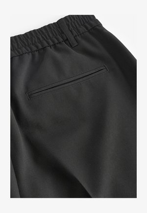 Pantaloni sportivi neri realizzati in un tessuto liscio, con vita elastica e una tasca posteriore discreta con zip nascosta.