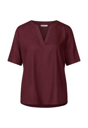 Blouse à manches courtes de couleur maroon avec un décolleté en V et un tissu lisse. Couleur droite avec un ourlet arrière légèrement plus long.
