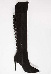 Black over-the-knee boot in soft suede with a pointed toe, high stiletto heel, side zipper, and crisscross lace detailing at the back.