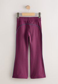 Pantaloni a zampa color marrone scuro in tessuto elasticizzato, con piping blu a contrasto lungo i lati e una texture liscia.
