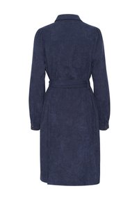 Robe ceinturée bleu marine à manches longues en tissu doux. Dispose d'un col et de poignets à bouton, ainsi qu'une texture lisse avec une silhouette évasée.