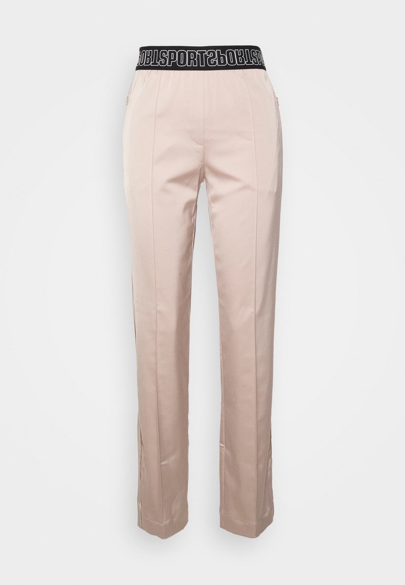 Pantalon ajusté rose pâle avec une taille élastique noire portant le mot « SPORTS ». Texture lisse et coupe droite, avec poches latérales.