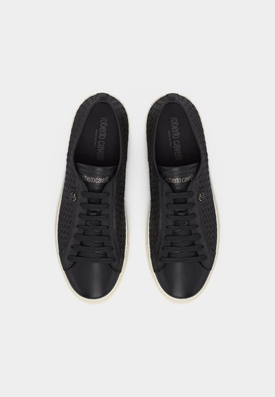Paire de baskets en cuir noir à lacets avec côtés texturés, semelles blanches, et marquage "Roberto Cavalli" sur les semelles intérieures et la languette.